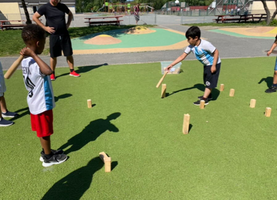 Elever spiller kubb i skolegården.