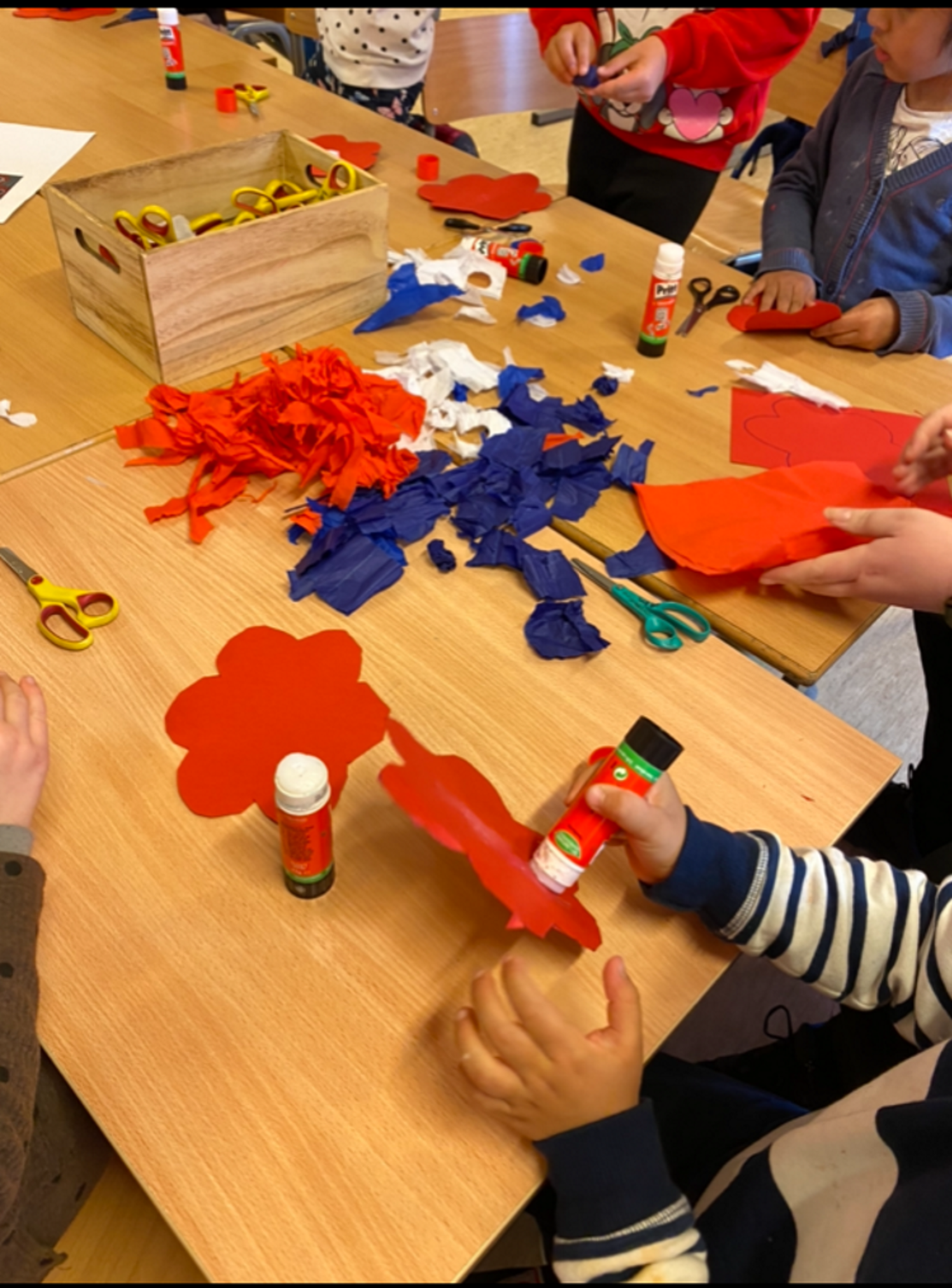 Elever klipper og limer i farget ark.