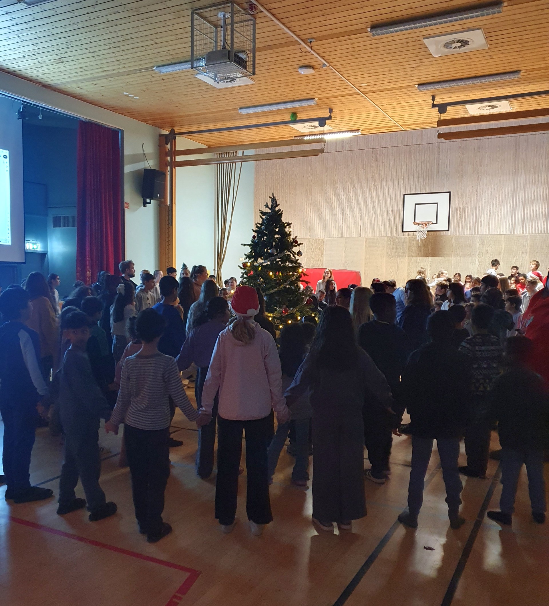 Elever og ansatte går rundt juletreet