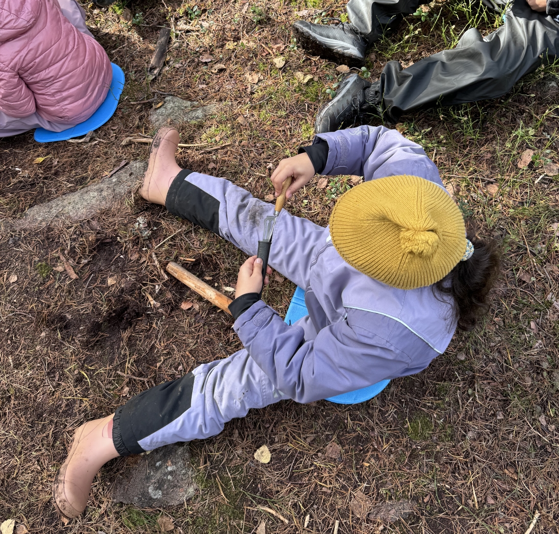 Et barn som spikker en pinne